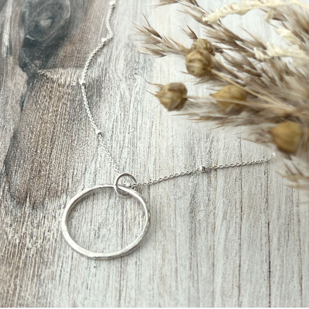 Aurora Unity Sterling Silver open circle pendant necklace - showing a close-up of the hand-hammered texture on the circle pendant.