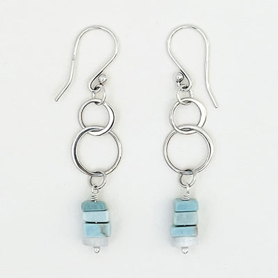 Elevate your style with these stunning sterling silver double-circle drop earrings, adorned with vibrant Natural Ice Blue Larimer heishi beads that add a captivating color pop. These earrings are sure to catch attention and be a delightful addition to any outfit, whether it's for a special occasion or a casual day out.