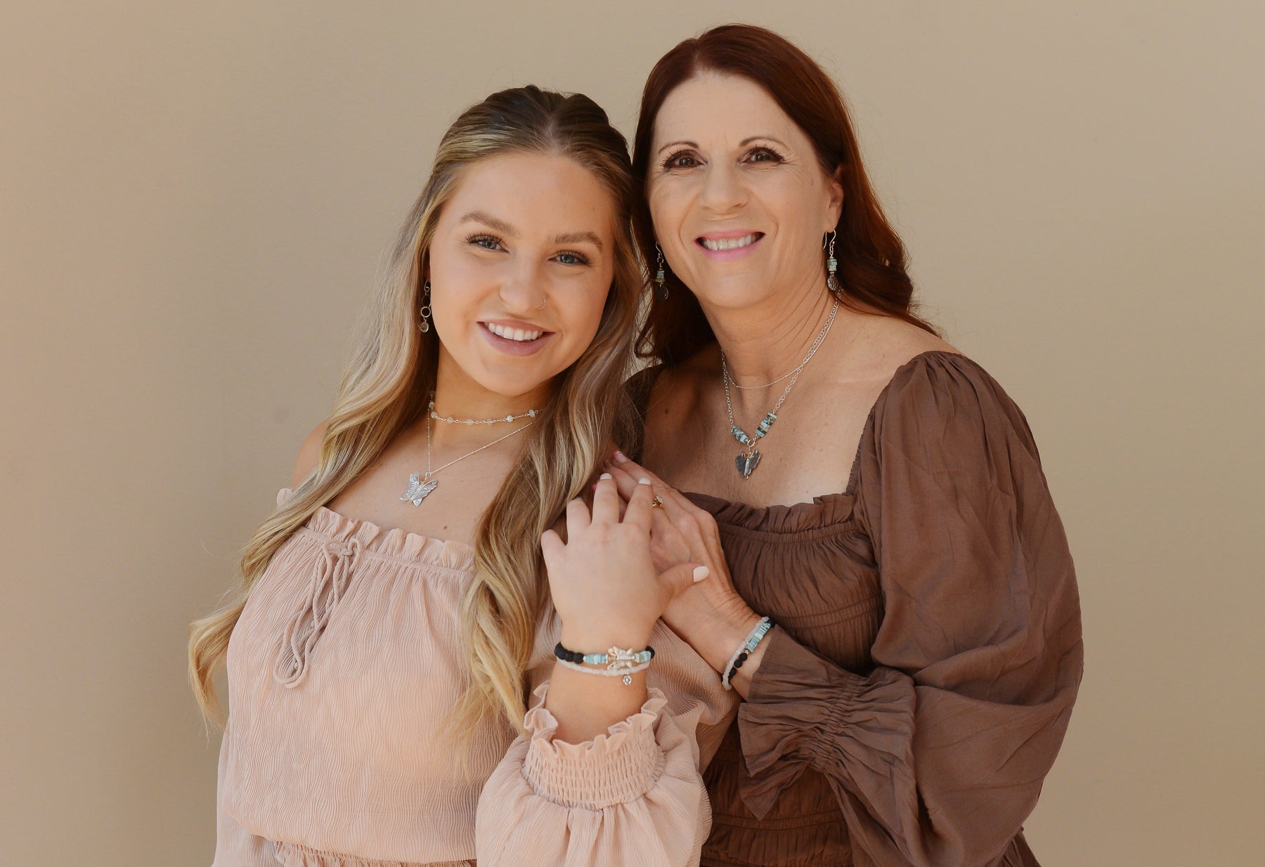 Mother and Daughter wearing Butterfly Bliss sterling silver necklaces with matching earrings and Butterfly with Turquoise and Lava Rock diffuser bracelets.
