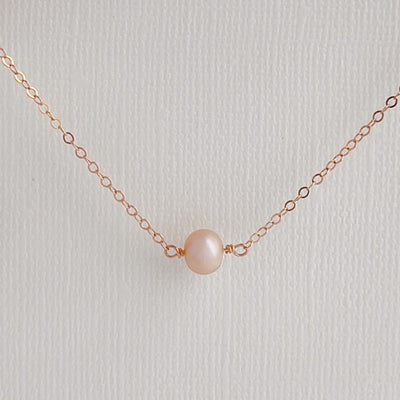 Elevate your look with this delicate layering pearl necklace. Featuring a single shimmery, creamy-rose colored pearl that is delicately set on a 14kt rose gold-filled chain, creating a luminous effect that captures the light beautifully.