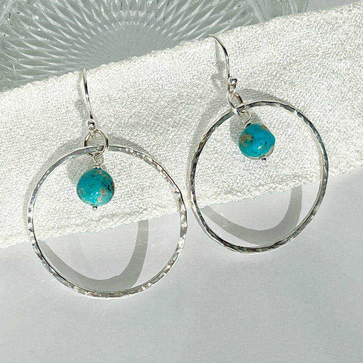 Enhance your outfit with these exquisitely designed large hoops, crafted with sterling silver and adorned with natural Sonora Turquoise Nugget Beads. The hammered texture adds a touch of shimmer, while the elegant turquoise exudes a southwestern charm.