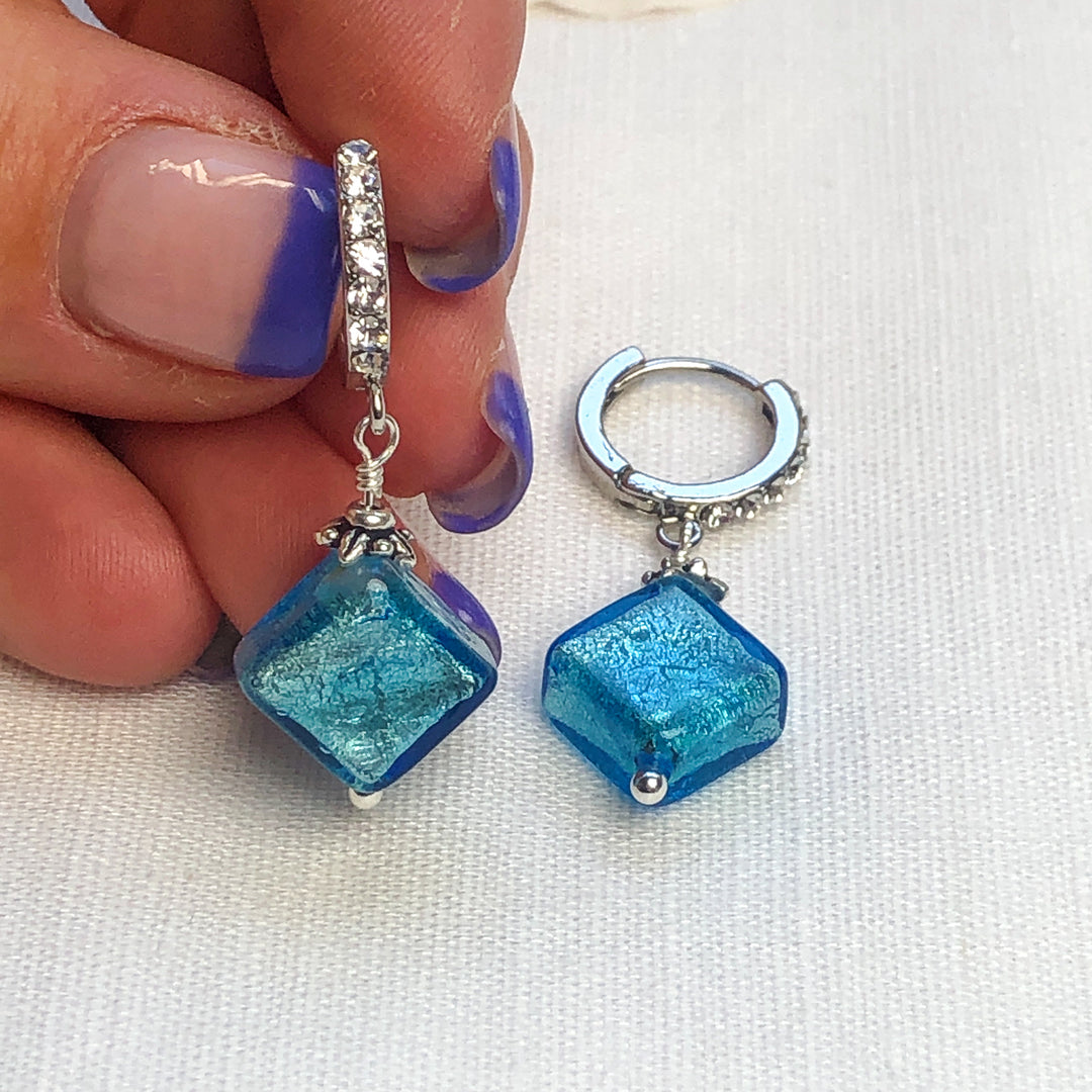 Stunning Aqua Murano Glass bead with white gold foil dangling from Sterling Silver & Cubic Zirconia huggie hoops. Authentic Murano Glass beads imported from Italy. Handcrafted in California