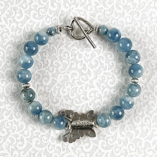 This sterling silver butterfly bracelet adorned with beautiful aquamarine gemstones is sure to catch the eye of admirers and become a statement piece. The heart toggle clasp gives the bracelet added whimsey.   Handcrafted in CA