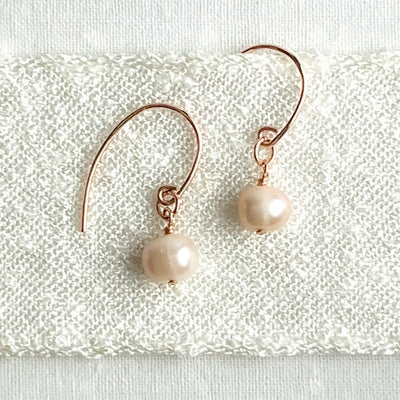 Delight in the beauty of these handcrafted freshwater pearls and 14Kt rose gold-filled earrings. The semi-round, creamy rose pearls are the perfect addition to your jewelry box for any occasion. Versatile enough to pair with a simple chain or freshwater pearl necklace, these earrings are a classic and timeless piece.
