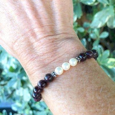 Semi-precious Garnet & Cream Rose Crystal Pearls in a lovely stretch bracelet to compliment your holiday wardrobe.  Shown on wrist. Handcrafted in CA.