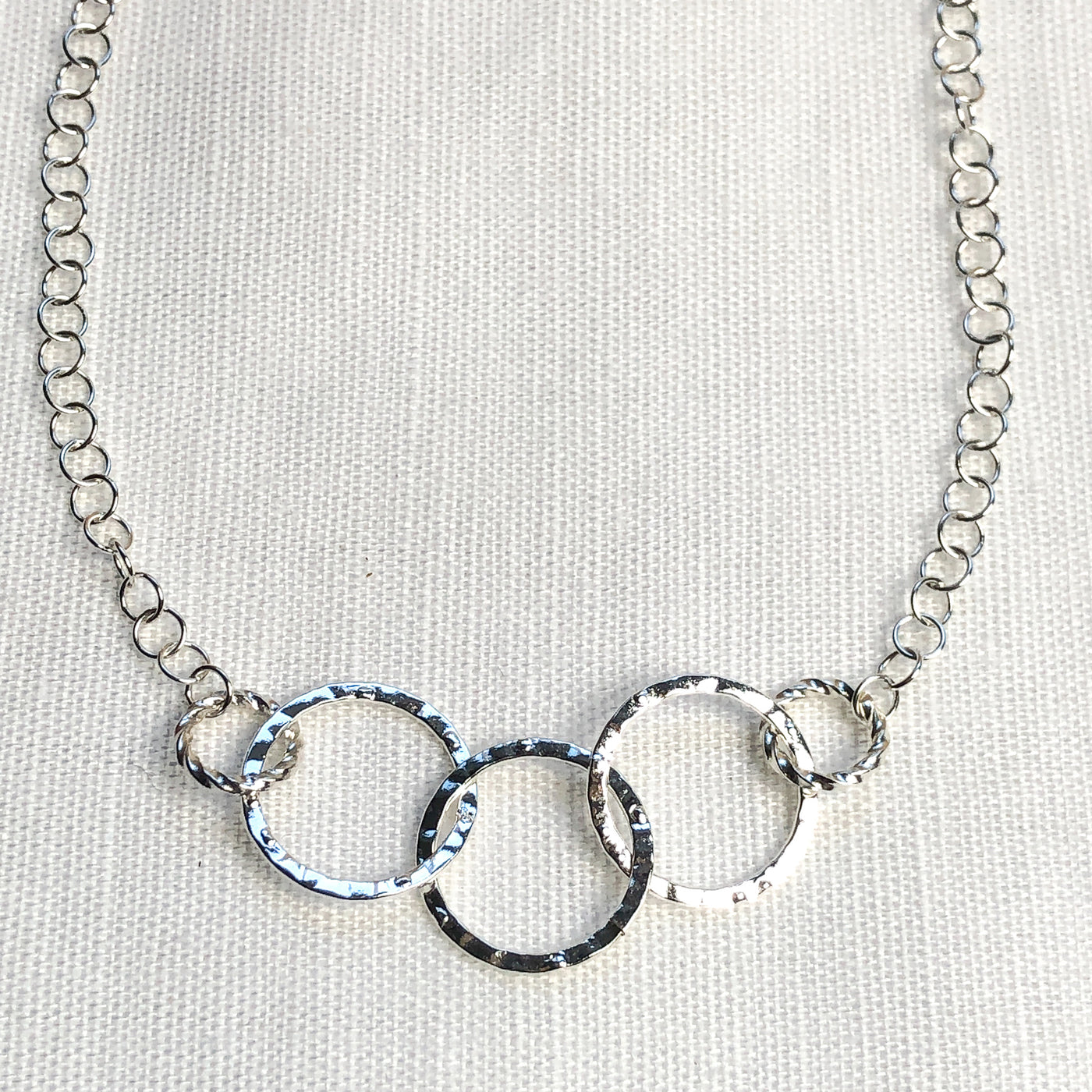 Lightweight & Graceful Silver Hammered Circle Necklace; 15 inches; Adjustable to fit lovingly on the neck. Detail View. Part of the Novaura Sparkle Set.